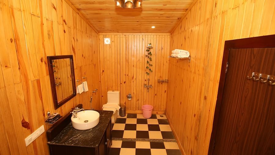 Kashmir Cottage Villa's Pool Room featuring a spacious washroom with wooden-style flooring, a modern sink, and a wall-mounted mirror at Aanandam Resort & Spa