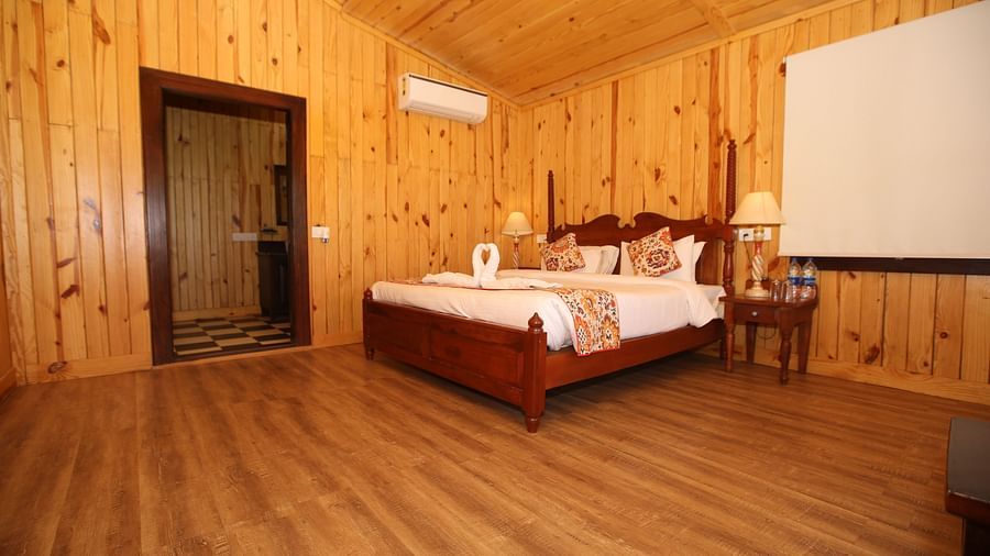 Spacious Kashmir Cottage Villa's Pool room with a king-sized bed, wooden flooring at Aanandam Resort & Spa