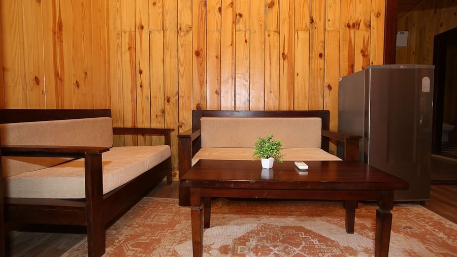 Cosy corner seating area featuring comfortable sofas, a table with a small plant pot, and a fridge in the corner