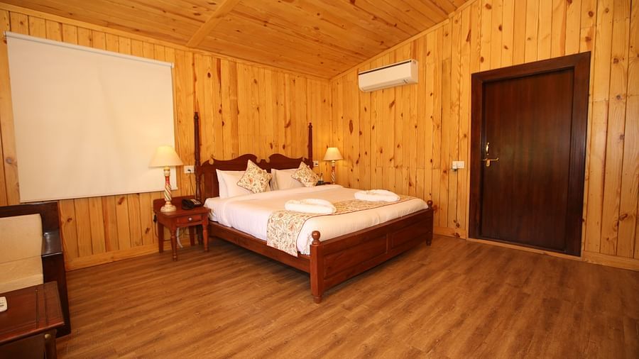 Kashmir Cottage Villa's Pool spacious room, featuring a king-sized bed and elegant wooden flooring at Aanandam Resort & Spa