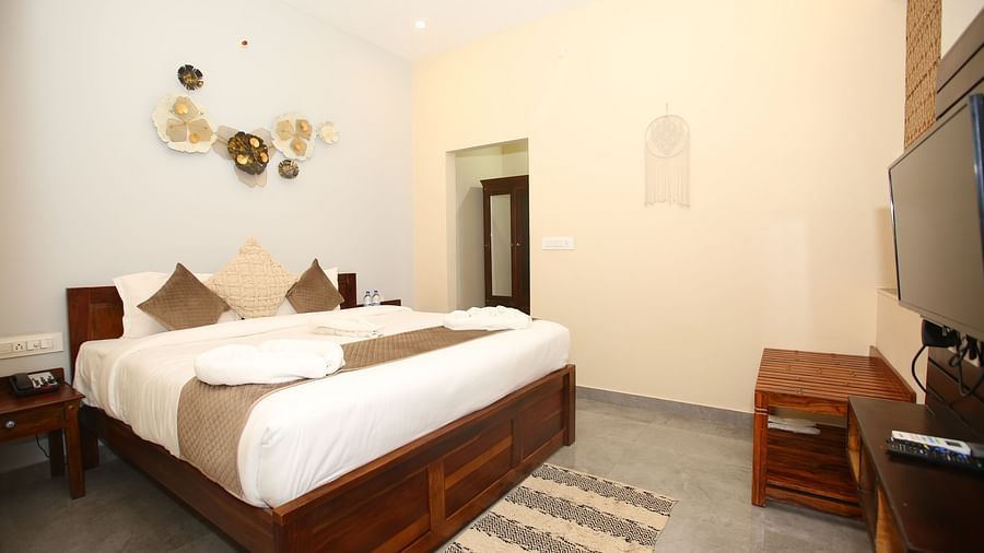 Studio Villa room with a spacious king-sized bed and a wall-mounted TV at Aanandam Resort & Spa