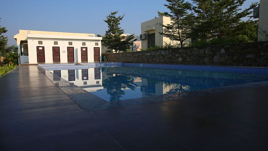 Open terrace swimming pool at Aanandam Resort & Spa, offering a serene view of the clear sky bathed in vibrant sunset hues