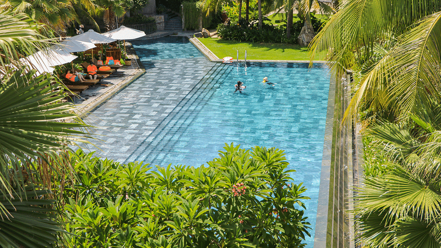 An image showcasing the pool at our resort with people enjoying a swim during a sunny day - Alibu Resort Nha Trang