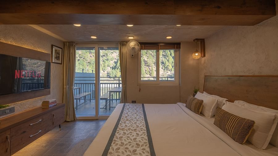 Room with double bed, TV, balcony doors, wooden beams on the ceiling, and soft lighting.C 1832-HDR