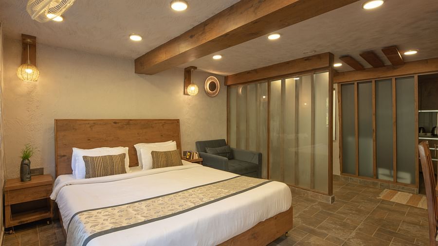 Room with double bed, wooden beams on the ceiling, and soft lighting.