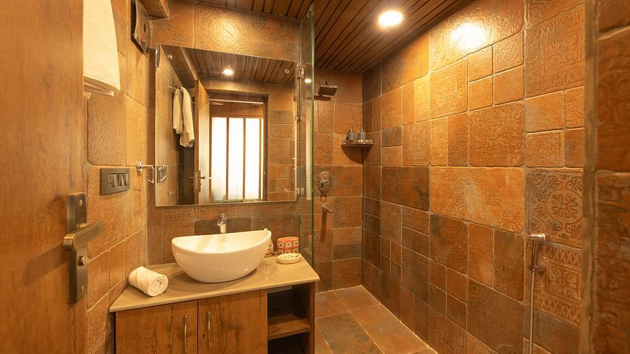 Clean bathroom with a white toilet, bidet sprayer, and small window, set against light walls