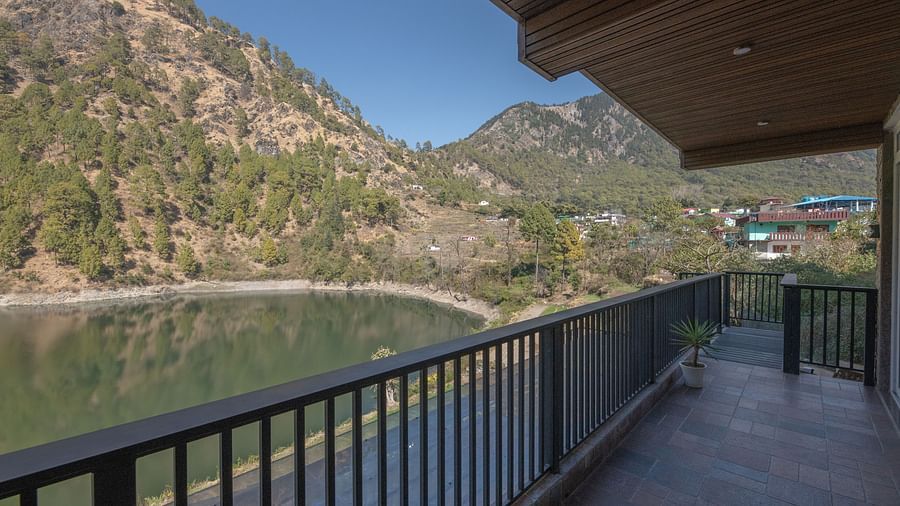 Narrow balcony with views of green hills and a clear sky.