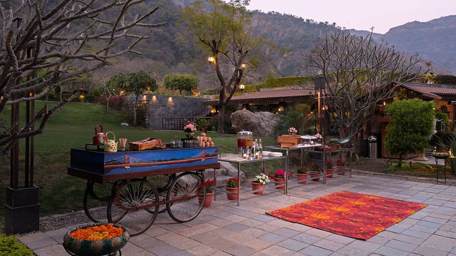 Food at outdoor food stations. There are mountains in the background and lush surrounding the scene.
