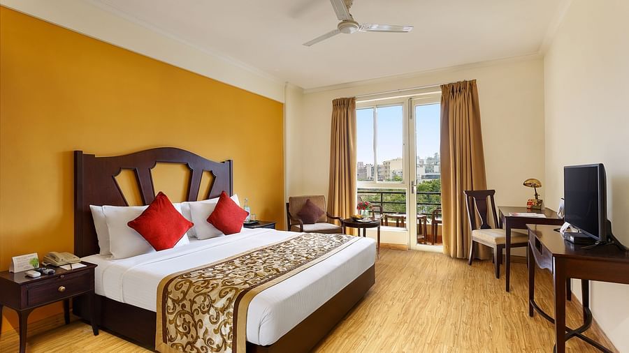 One bedrooom standard apartment with a large bed facing a television and a workdesk and ceiling fan - Aloha On The Ganges, Rishikesh