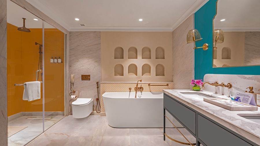 An image of the bathroom featuring a large bathtub, a separate glass-enclosed shower, and a double vanity.