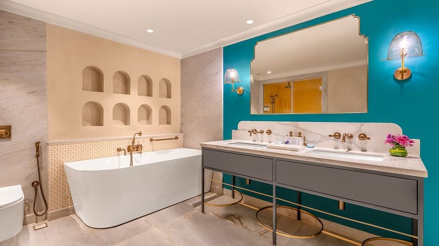 An image featuring a luxurious bathroom with a freestanding bathtub, a double vanity, and a large mirror.