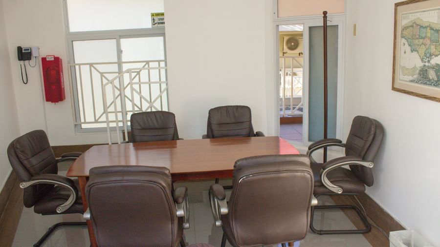 A conference room with a large table and chairs, set up for a meeting or discussion | Breakaway Room | Altamont Court, Jamaica