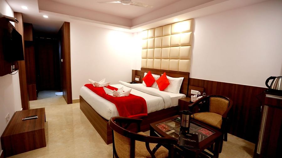 Side view of a room with a bed and a seating area on the side Amara Hill Queen, Mussoorie.