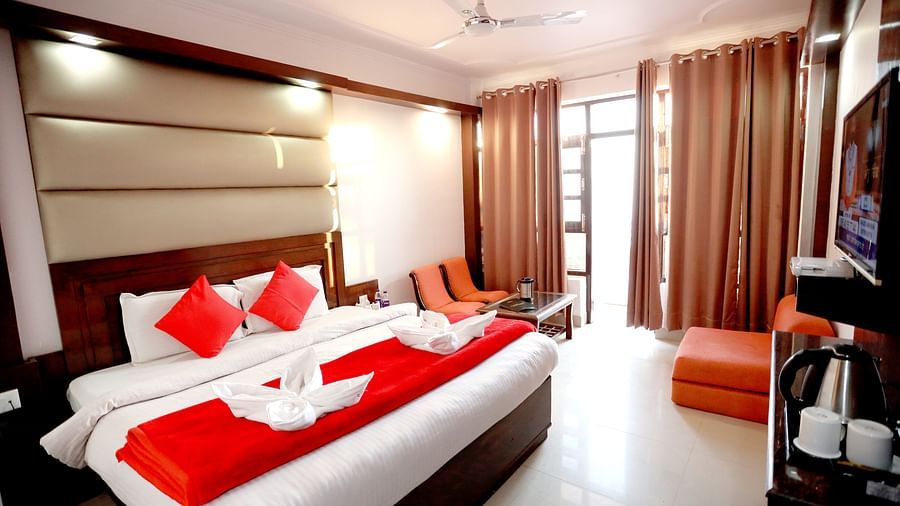 Image of a room with a bed and a door on the side at Amara Hill Queen, Mussoorie.