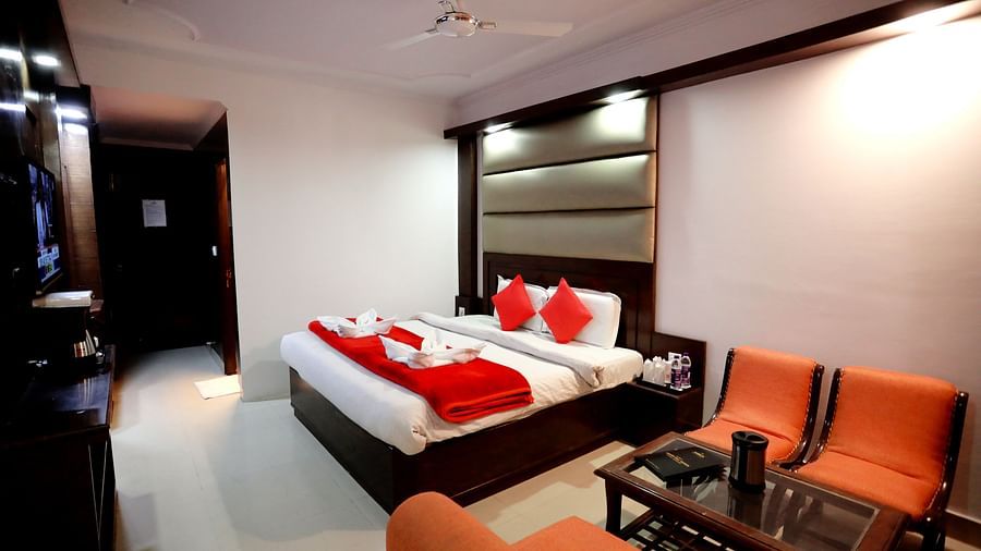 Image of a room with a bed and a seating area on the side at Amara Hill Queen, Mussoorie.