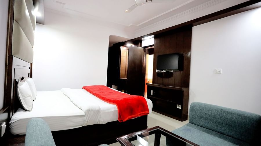 Side view of a room with a bed and a sofa on the side with a coffee table in front of it.