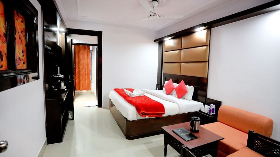 Image of a room with a bed and a seating area on the side at Amara Hill Queen, Mussoorie.