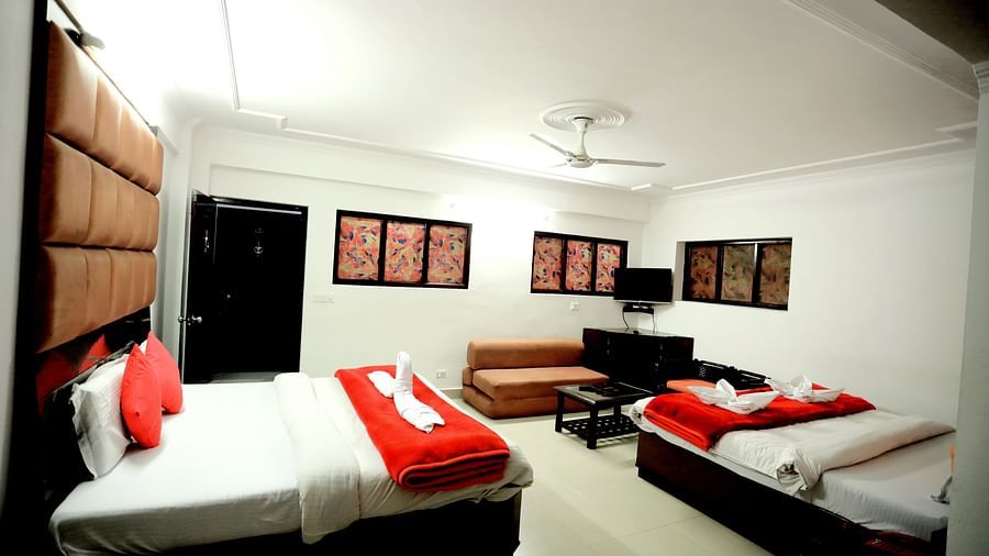 Image of a room with two beds and a television mounted on the wall at Amara Hill Queen, Mussoorie.