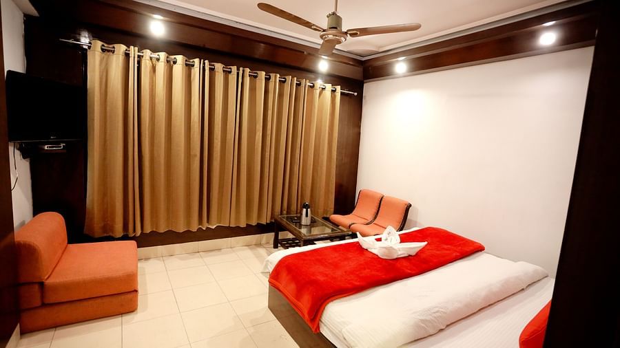 Image of a room with a bed and a seating area on the side at Amara Hill Queen, Mussoorie.
