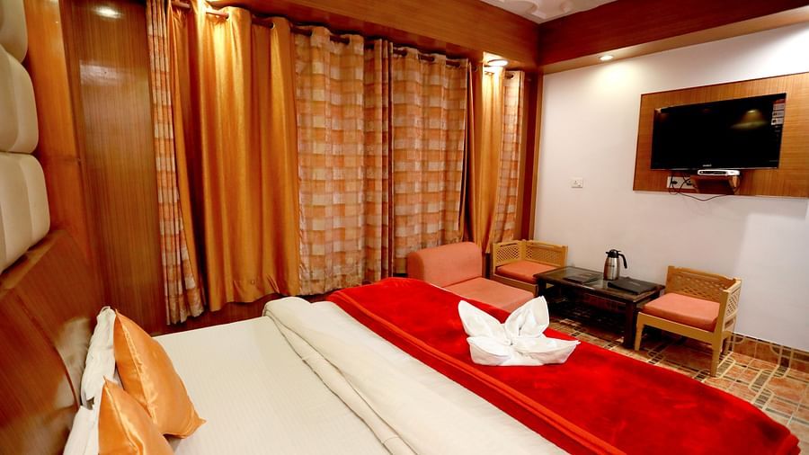 Image of a room with a bed and a television in front at Amara Hill Queen, Mussoorie.