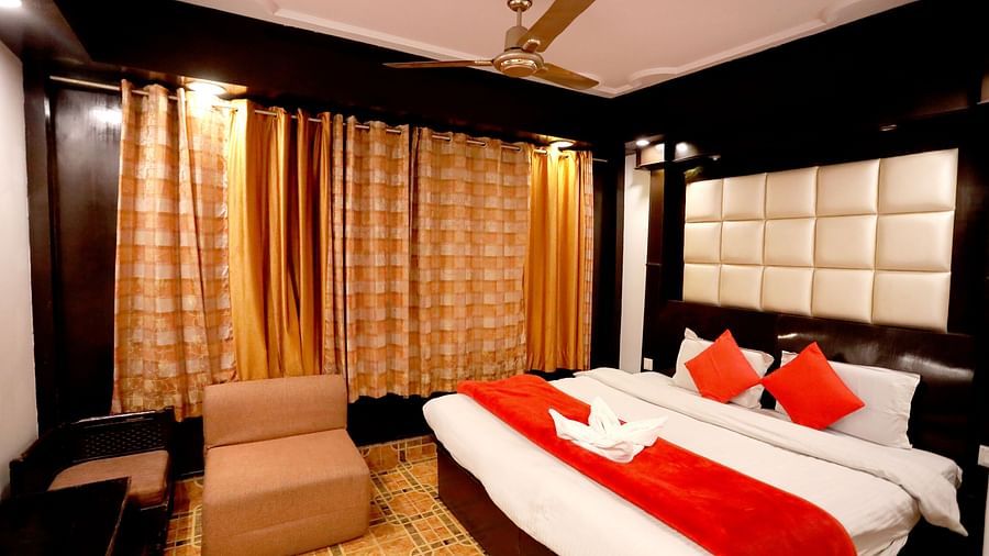 Image of a room with a bed and a sofa in front at Amara Hill Queen, Mussoorie.