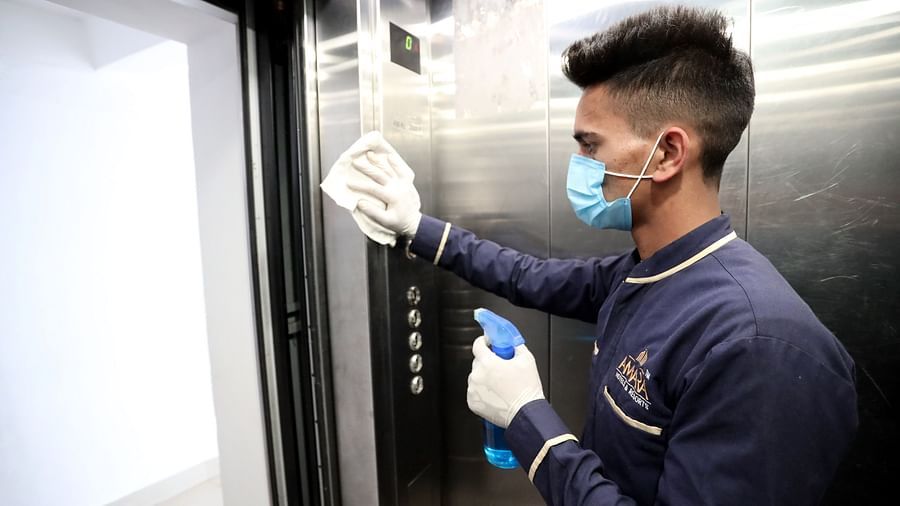 Image of a man cleaning the inside of a lift at Amara Hill Queen, Mussoorie.