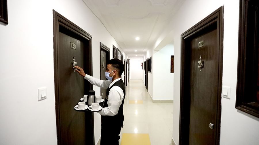 Image of a man holding a try and knocking the door at Amara Hill Queen, Mussoorie.