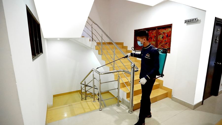 Image of a man cleaning the railing of a staircase at Amara Hill Queen, Mussoorie.