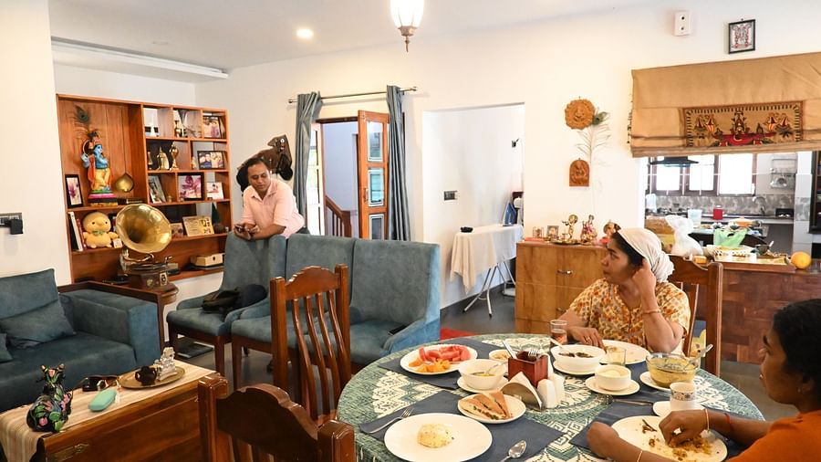 Dining area at Ananda Holiday Home, Wayanad with people sitting at the dining table with food in front of them