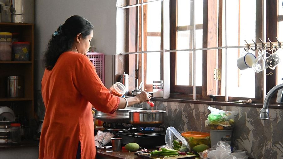 A women cooking in the kitchen at Ananda Holiday Home, Wayanad