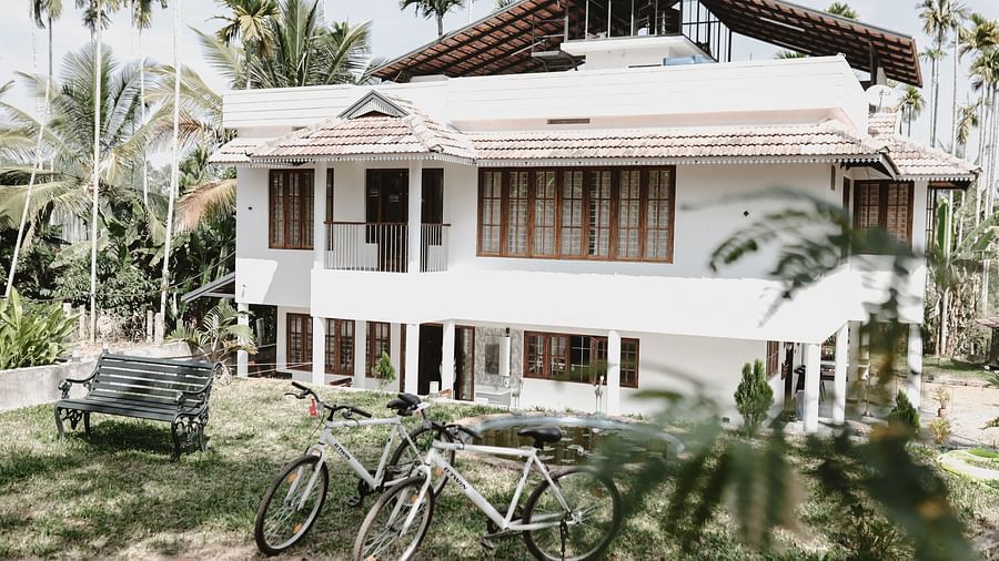 2 bicycles standing in front of the Facade of Ananda Holiday Home, Wayanad