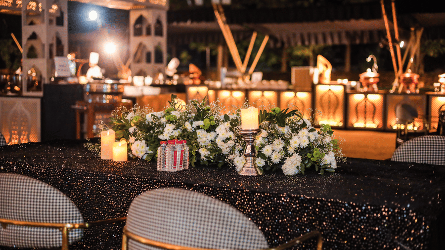 A dining display with dishes, serving counters, chairs and floral arrangements at Ananta Spa and Resort, Jaipur
