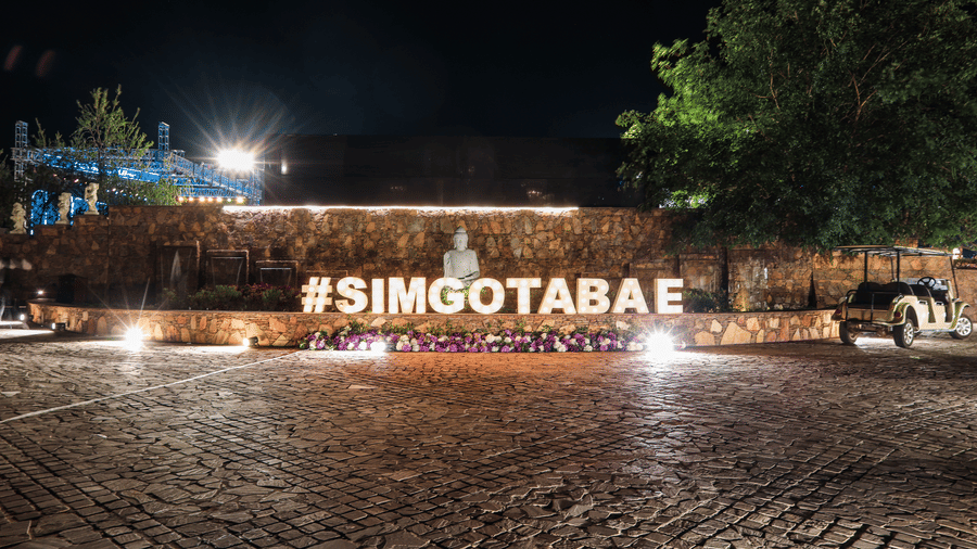 An outdoor space with a lit sign reading SIMGOTABAE at Ananta Spa and Resort, Jaipur