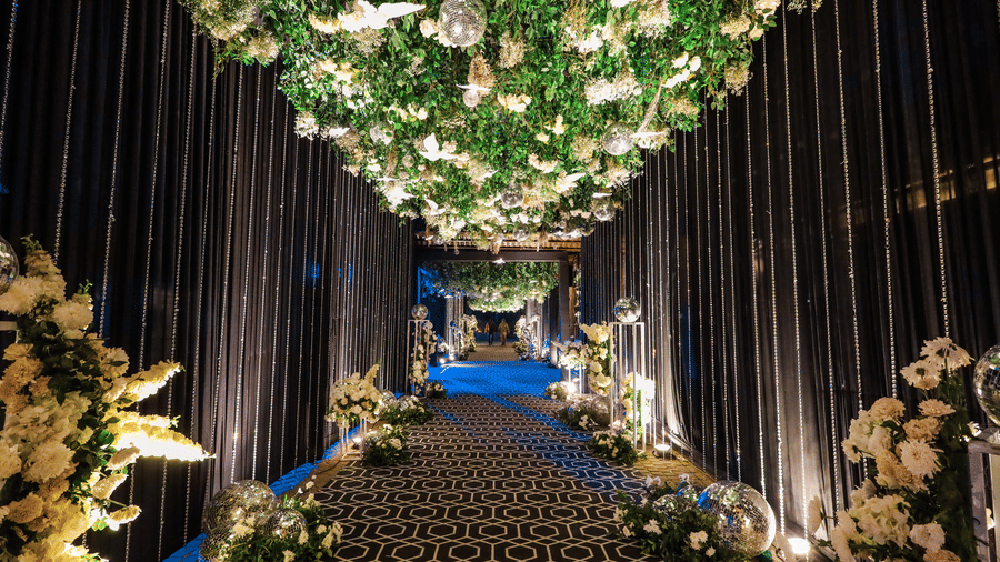 Floral walkway decorated with hanging lights and green canopy at Ananta Spa and Resorts, Jaipur.