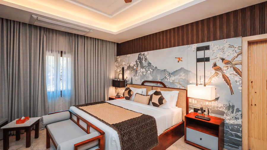 An overview of the Grand Suites in Jaipur at Ananta Resort & Spa, Jaipur, with side tables, lamps and a ceiling fan in view.