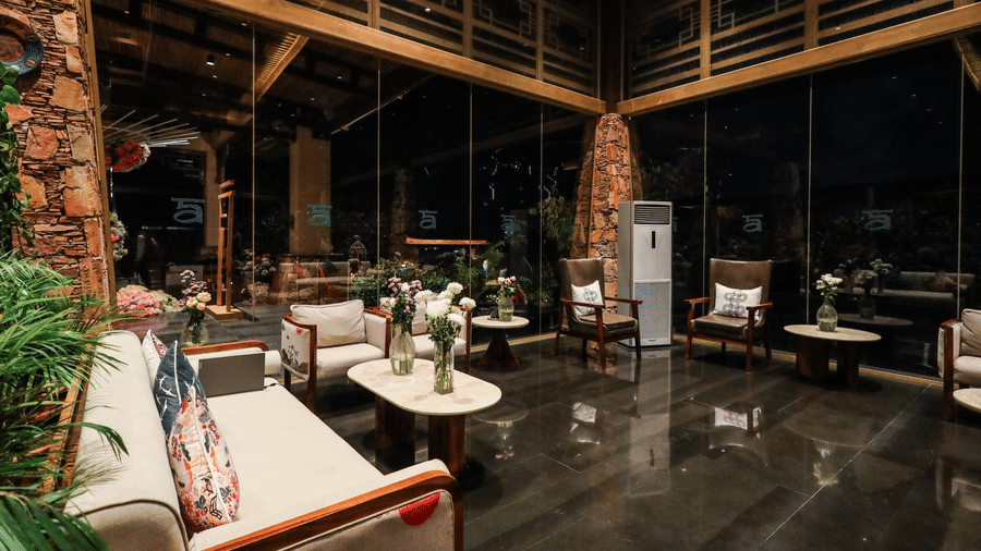 A warmly lit, sophisticated lobby lounge at Ananta Spa & Resort, Jaipur, features plush seating and large windows at night.