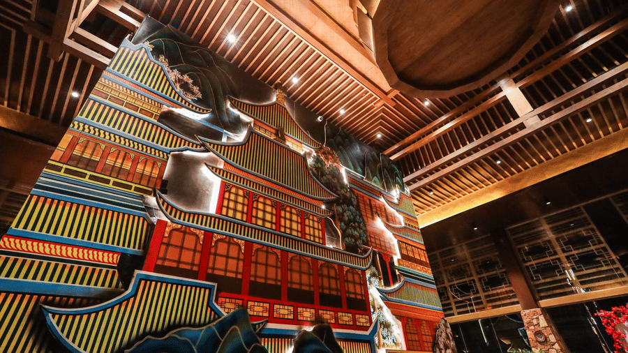 A dramatic, low-angle view of the large, colourful, three-dimensional pagoda mural on the wall at Ananta Spa & Resort, Jaipur.