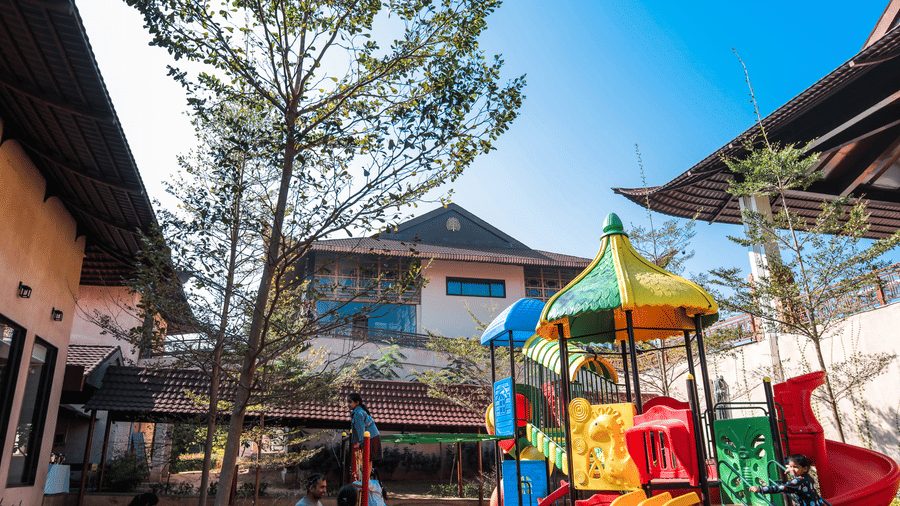 A play area with slides, climbing structures and surrounding buildings at Ananta Spa and Resort, Jaipur