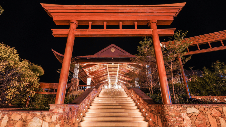 A staircase leading to a large gateway structure with trees on both sides at Ananta Spa and Resort, Jaipur