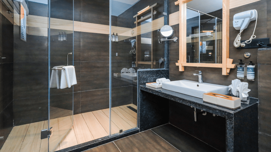 A bathroom with a vanity counter, sink, mirror and shower enclosure at Ananta Spa & Resort, Jaipur.