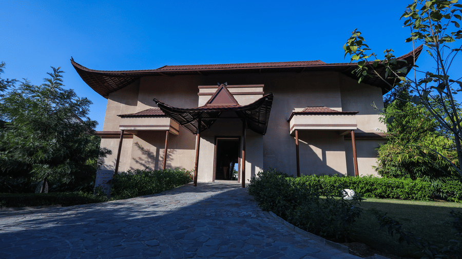 A villa entrance with a pathway, plants and a large doorway at Ananta Spa and Resort, Jaipur