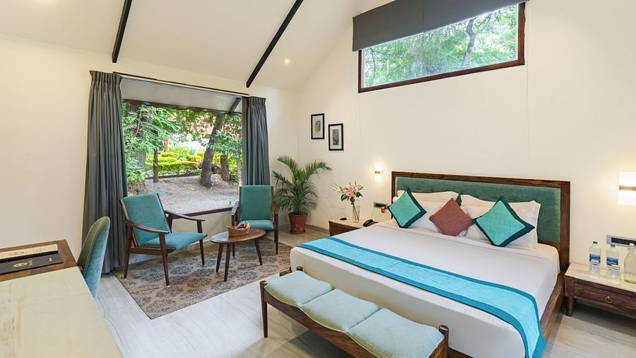 full view of the luxury villa at aranya vilas featuing a king size bed in a brightly lit room with ample natural light falling in the room