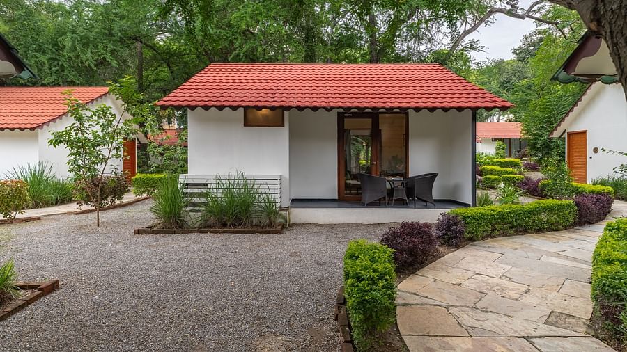 facade image of the luxury pond view villa with terracotta roof with a pathway in front of it