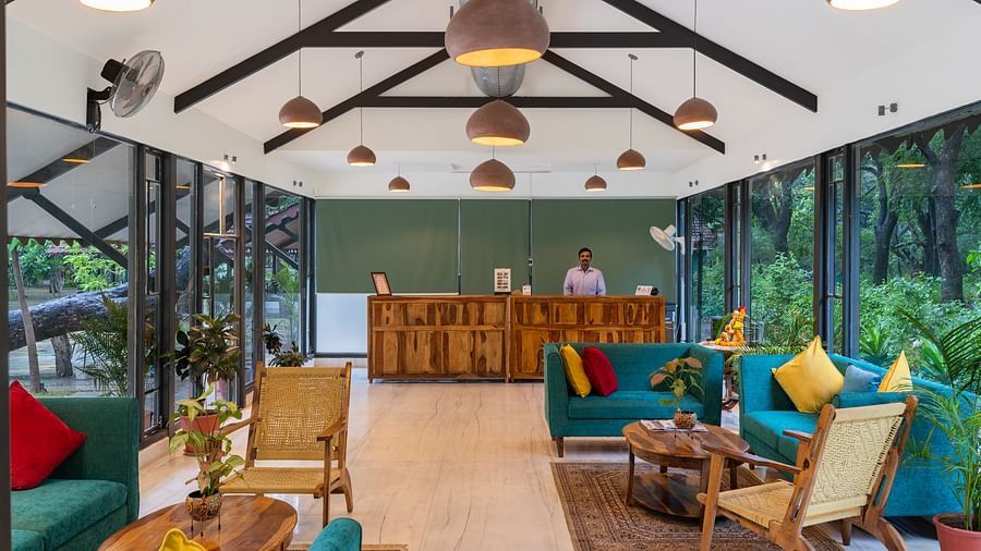 image of the lobby highlighting the front desk of aranya vilas with teal coloured couch with yellow cushions