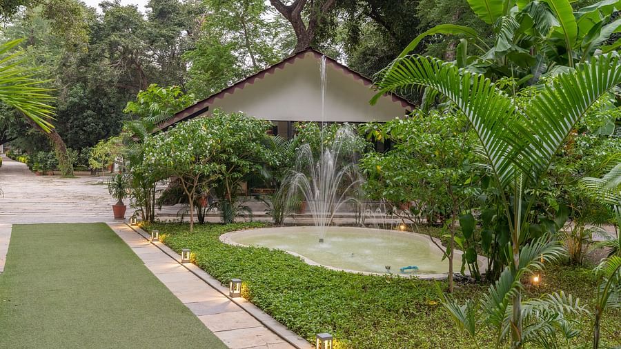image featuring a pond with a fountain in front of a villa in aranya vilas