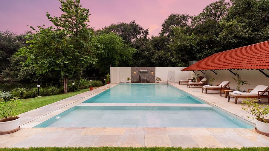 image of the swimming pool under a beautiful evening sky at the aranya vilas by mertia hospitality
