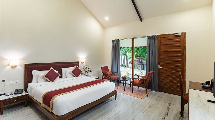 image of the luxury bathtub villa featuring a plush comfortable king size bed and huge french windows in the far end of the room at aranya vilas in udaipur