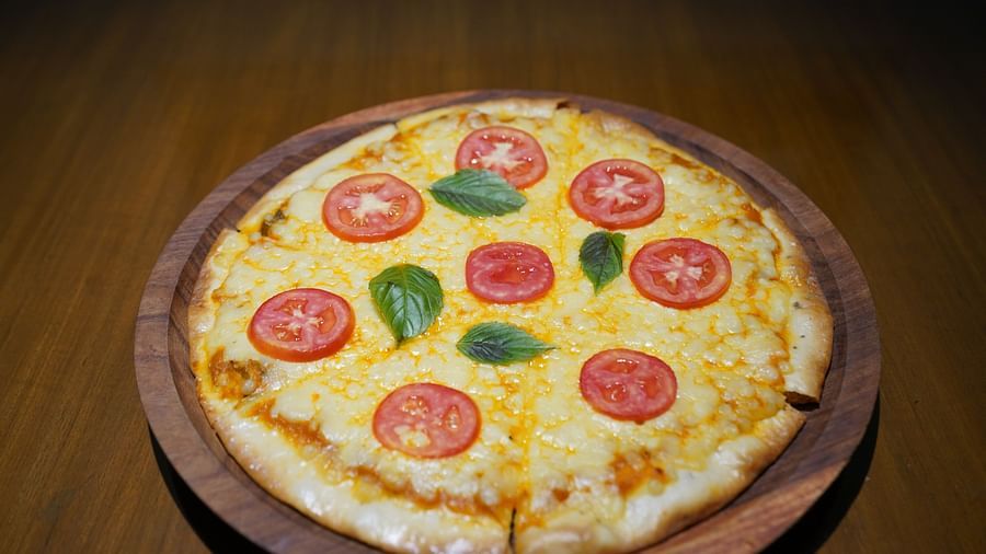 An image of a pizza placed at a table - Argo By Trance, Goa