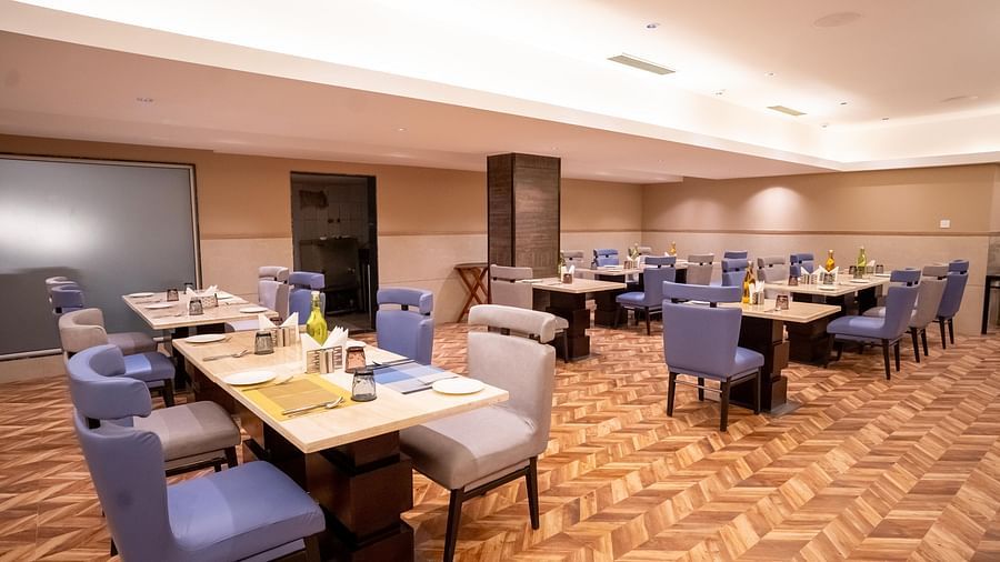 Nutmegg restaurant with neatly arranged tables and chairs at ASTER GRAND BY ZENQ SAKET.