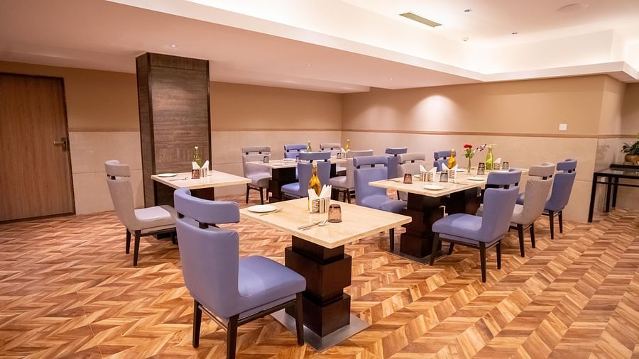 Nutmegg restaurant with neatly arranged tables and chairs at ASTER GRAND BY ZENQ SAKET.